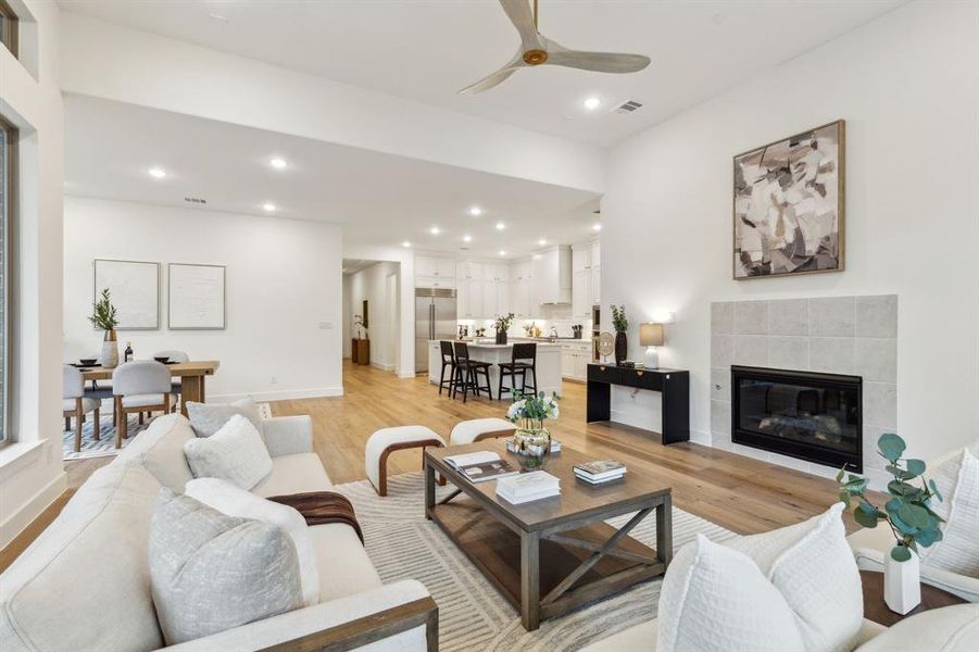 Living room featuring ceiling fan, light hardwood / wood-style floors, and a tile fireplace