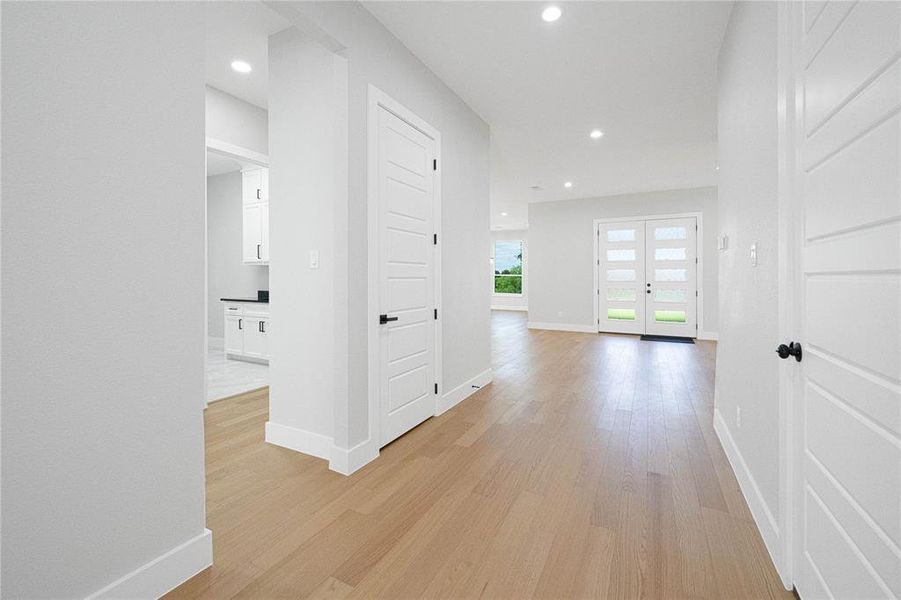 Corridor featuring light wood-style floors and recessed lighting