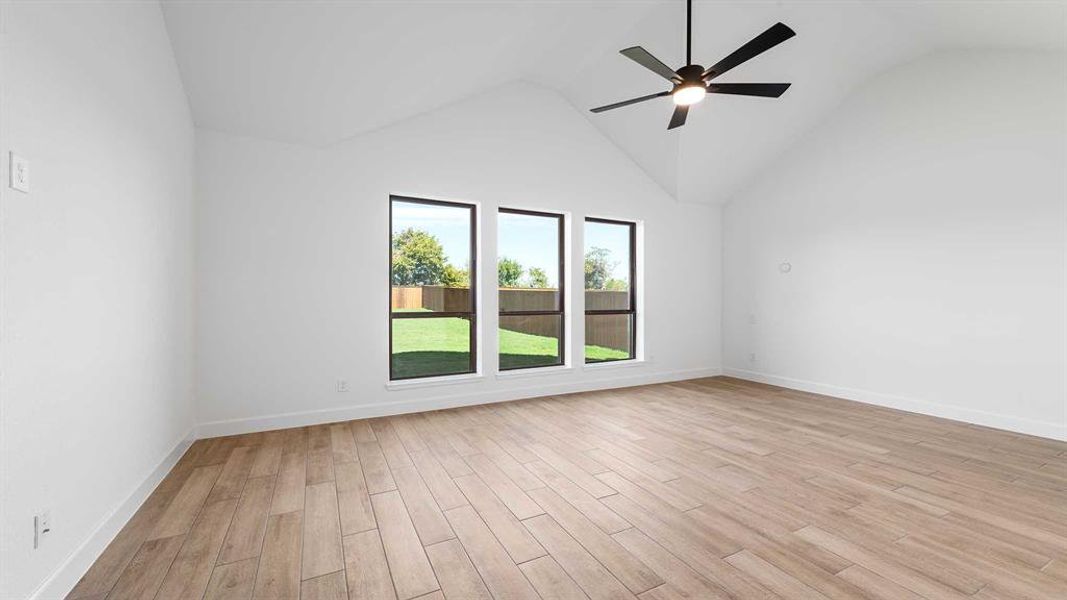 Unfurnished room featuring high vaulted ceiling, light wood-type flooring, and ceiling fan