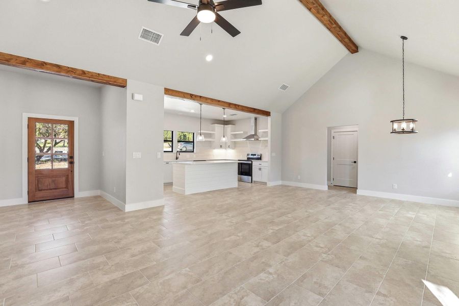 Discover an open-concept living space with vaulted ceilings, exposed beams, and a well-appointed kitchen. Discover an open-concept living space with vaulted ceilings, exposed beams, and a well-appointed kitchen.