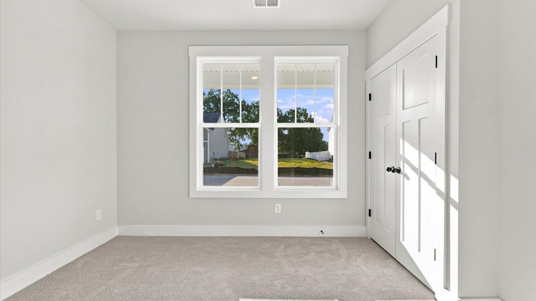 Superior comfort in this light-filled bedroom with plush carpeting and thoughtfully placed large windows