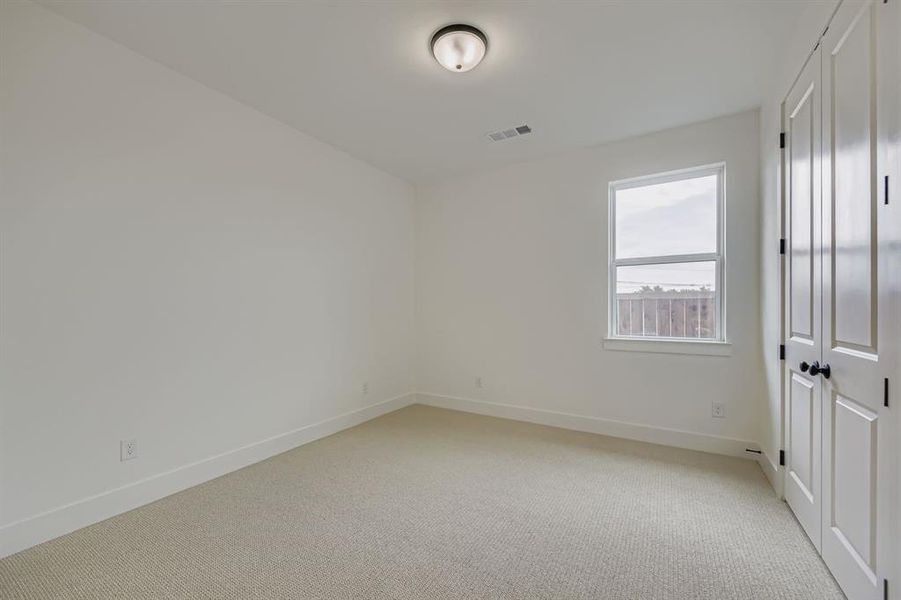 Unfurnished bedroom with a closet and light carpet Unfurnished bedroom with a closet and light carpet