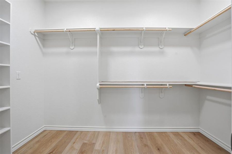 Spacious closet with light wood-style floors Spacious closet with light wood-style floors