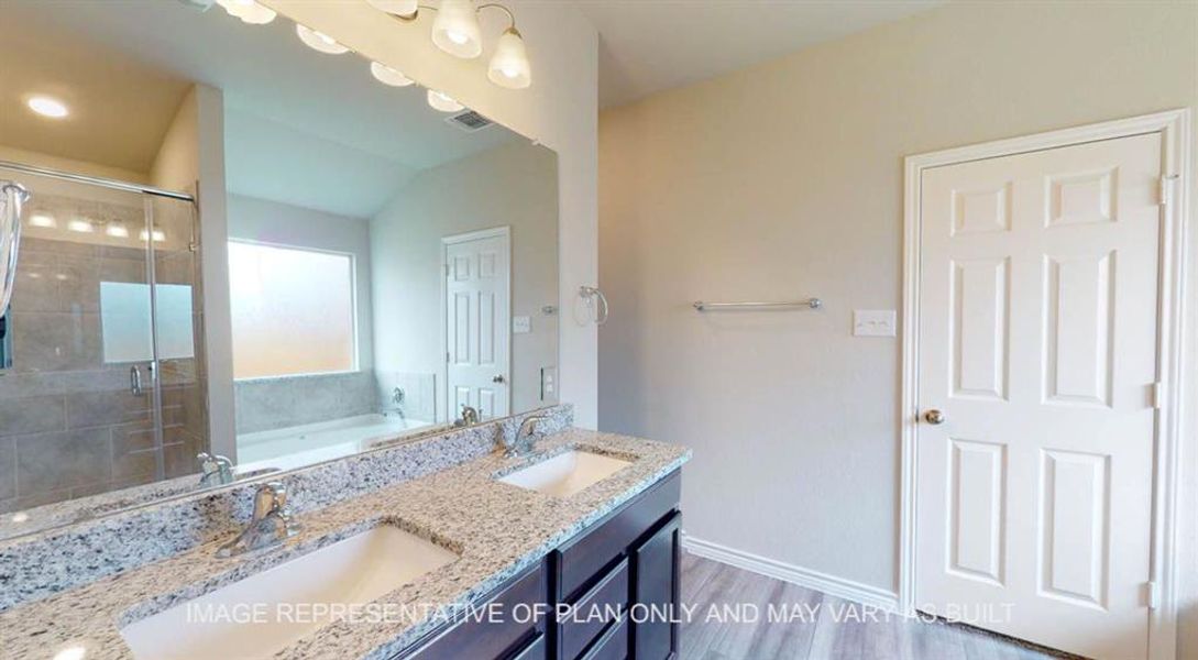 Bathroom featuring a stall shower, a garden tub, double vanity, and light wood-type flooring Bathroom featuring a stall shower, a garden tub, double vanity, and light wood-type flooring