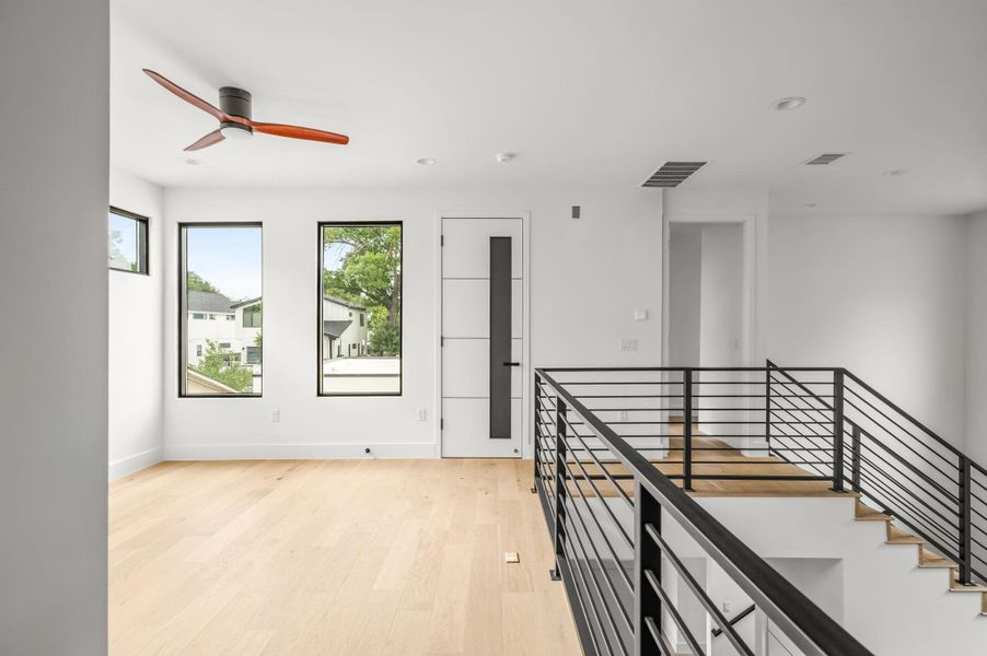 Blonde hardwood floors flow through this luminous upstairs loft, offering clear views and modern railing. Blonde hardwood floors flow through this luminous upstairs loft, offering clear views and modern railing.