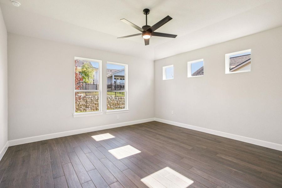 Spare room featuring dark wood-style floors and a ceiling fan Spare room featuring dark wood-style floors and a ceiling fan