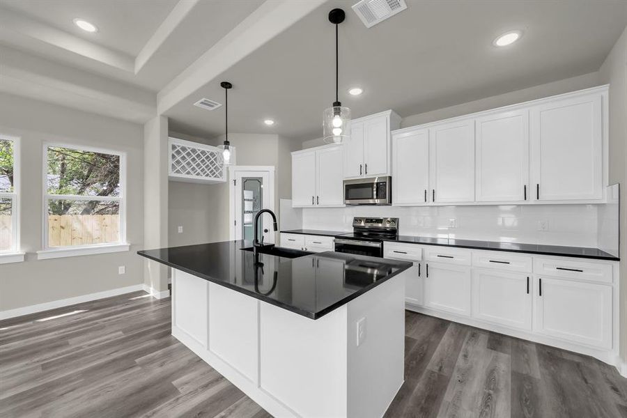 Kitchen featuring stainless steel appliances, sink, hardwood / wood-style flooring, and white cabinets