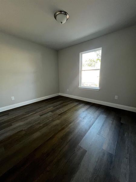 Empty room featuring dark hardwood / wood-style floors