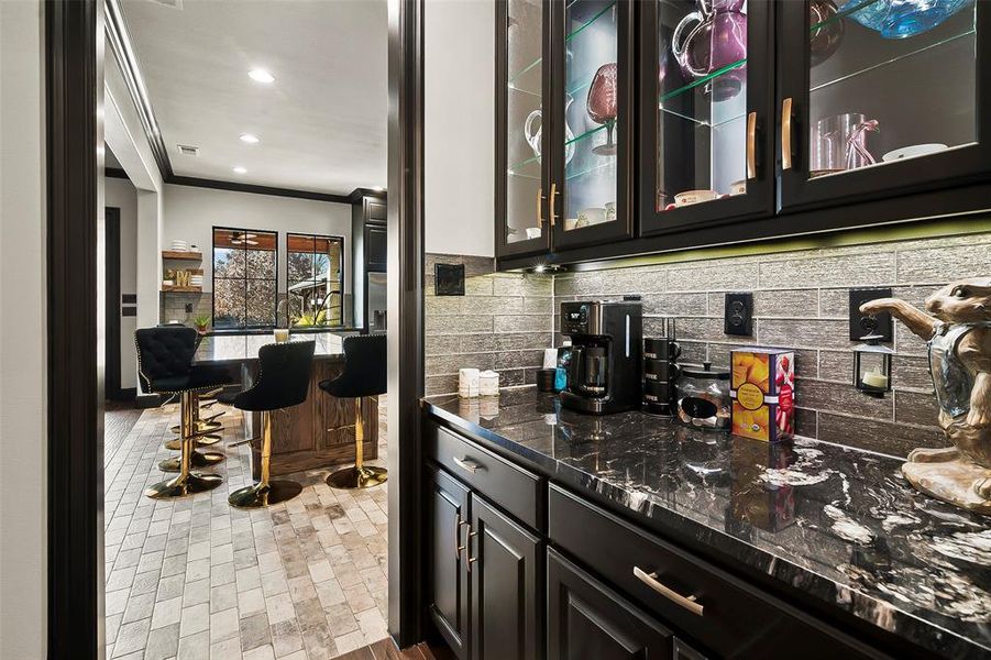 Butlers pantry with lighted glass front cabinets, gorgeous granite and built in cabinets,