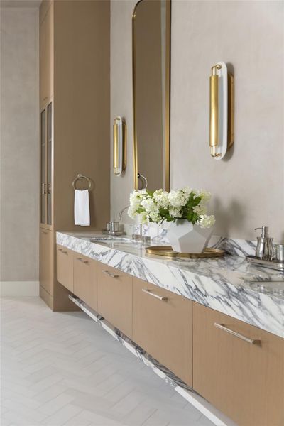 Custom white oak cabinetry, a marble vanity top, and dual sinks exude pure elegance. Custom white oak cabinetry, a marble vanity top, and dual sinks exude pure elegance.