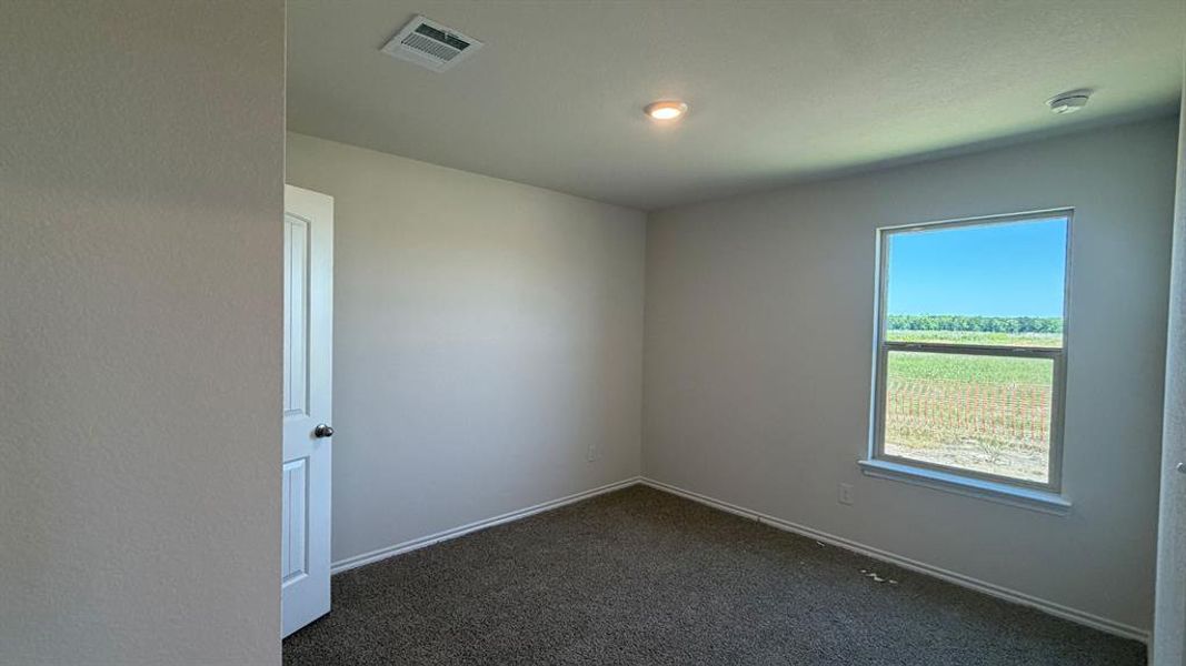 Carpeted room featuring a single window, recessed lighting, and a white paneled door