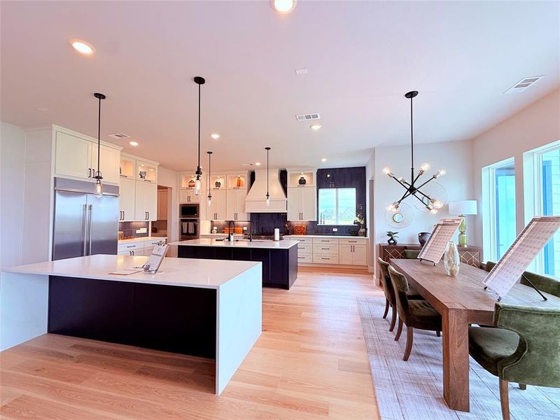 Open-concept kitchen and dining area featuring light wood-finish flooring