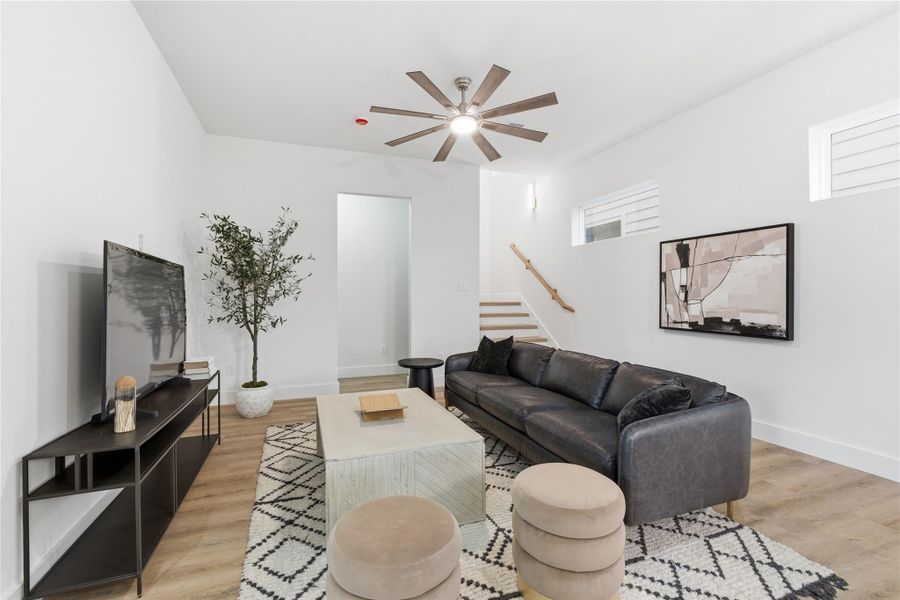 Finished with a comfortable living area featuring high ceilings and clean lines, offering a relaxed space that complements the home’s open flow.