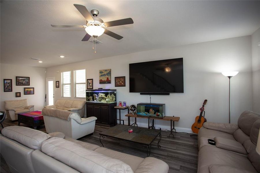 Living area featuring wood finished floors, recessed lighting, a ceiling fan, and baseboards