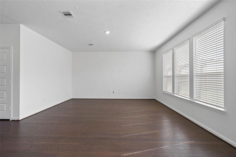 This light and bright spacious Great Room is the perfect layout for entertaining or just relaxing. Whether it's simply a night in or entertaining family and friends, this home has ample open space for everyone to enjoy! Featuring engineered wood flooring, large windows with blinds, high ceilings, recessed lighting, and wonderful access to the kitchen and dining area.