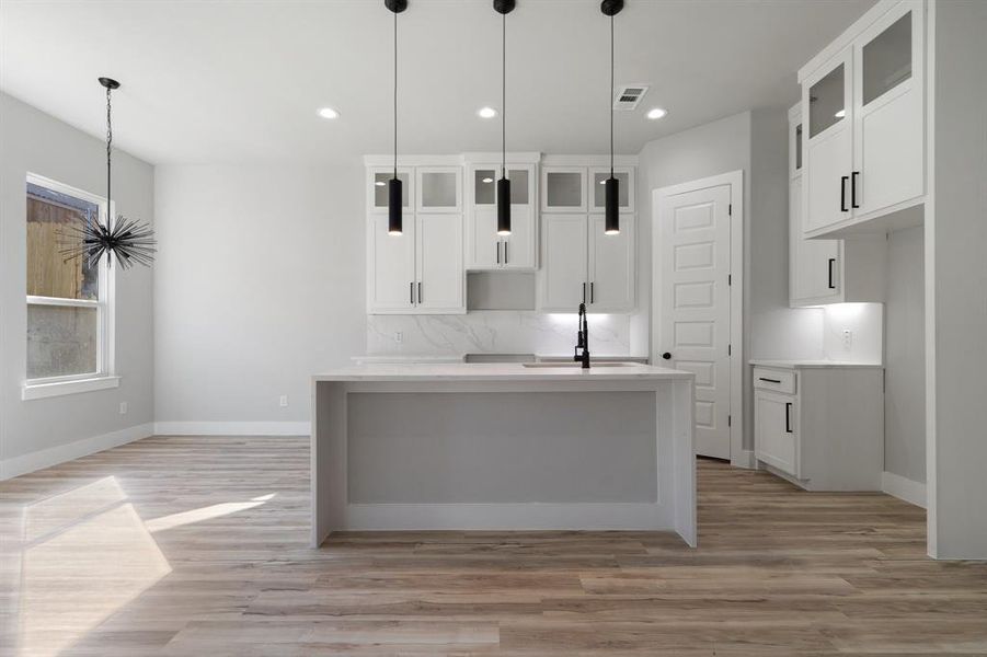 Kitchen with sink, white cabinets, and light wood-type flooring