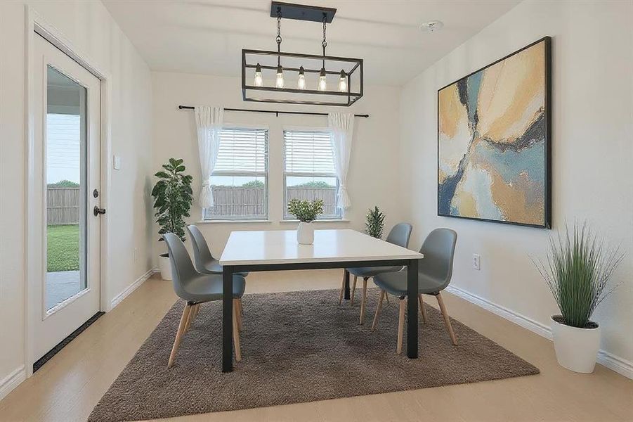 Dining space with light wood-style floors and baseboards