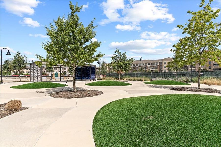Expansive outdoor space featuring concrete pathways and artificial turf islands