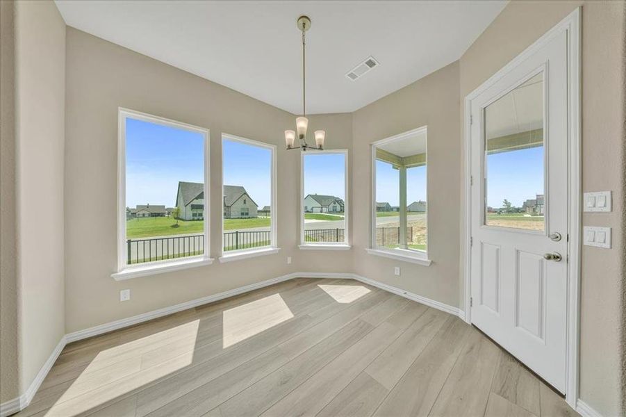 Unfurnished dining area with a chandelier and light wood-style flooring Unfurnished dining area with a chandelier and light wood-style flooring