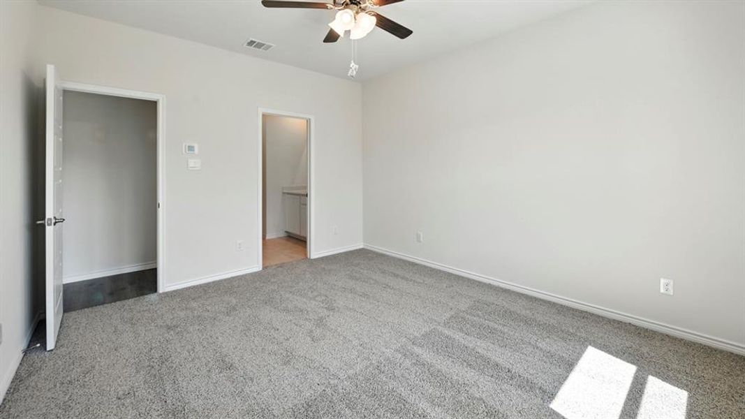 Unfurnished bedroom with light carpet, a ceiling fan, and ensuite bathroom Unfurnished bedroom with light carpet, a ceiling fan, and ensuite bathroom