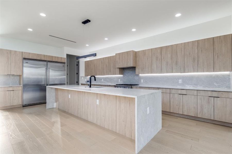 Kitchen with modern cabinets, stainless steel appliances, and built in fridge