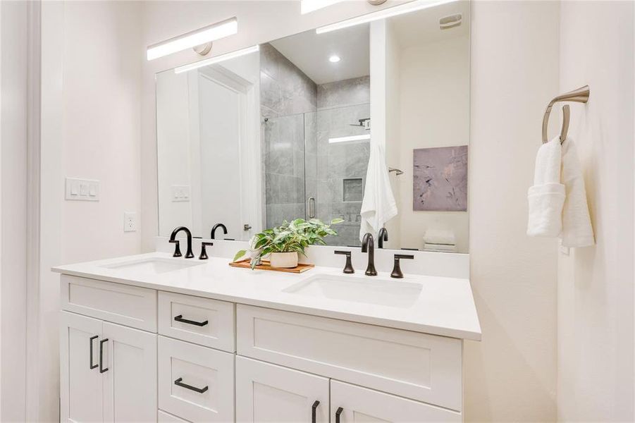 Bathroom with toilet, a shower with door, and vanity