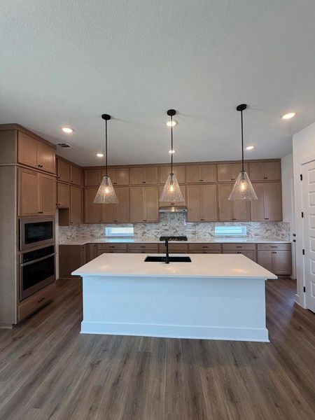 Culinary dreams come alive in this well-appointed kitchen featuring a substantial island with seating.