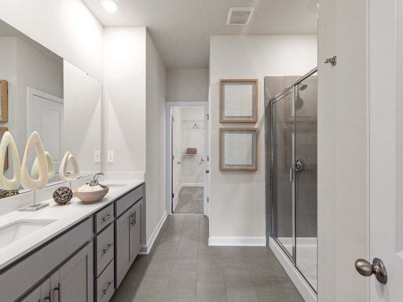 The primary bathroom boasts a dual-sink vanity and modern walk-in shower.