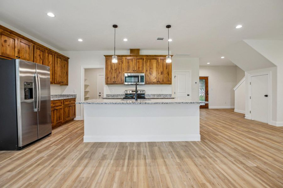 Kitchen with brown cabinets and appliances with stainless steel finishes