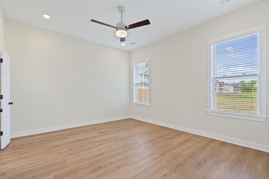 Bright room with wood-finish flooring and neutral wall tones Bright room with wood-finish flooring and neutral wall tones