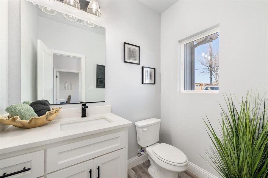 Bathroom featuring vanity, hardwood / wood-style floors, and toilet