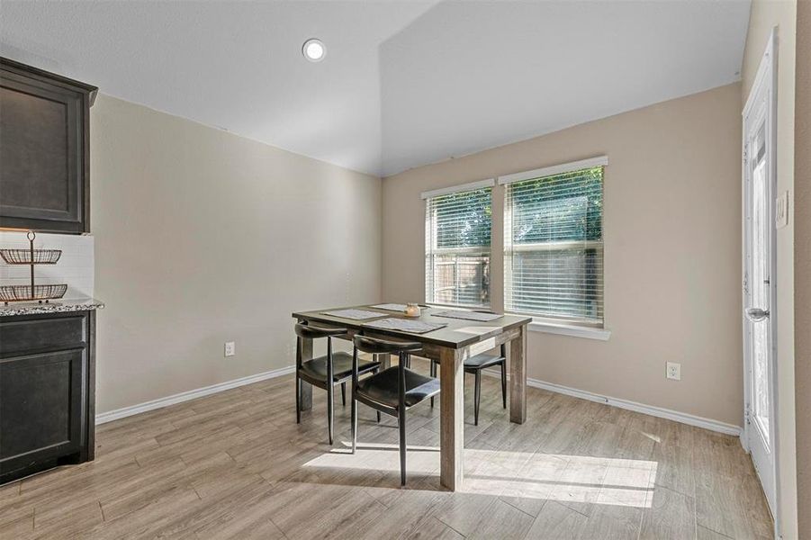 Dining area featuring lofted ceiling and light hardwood / wood-style flooring