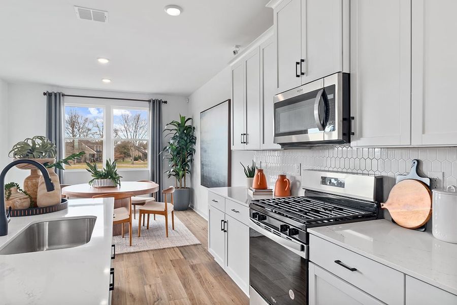 A kitchen with white cabinets.