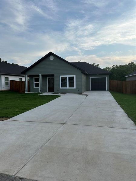 Ranch-style house with concrete driveway and an attached garage
