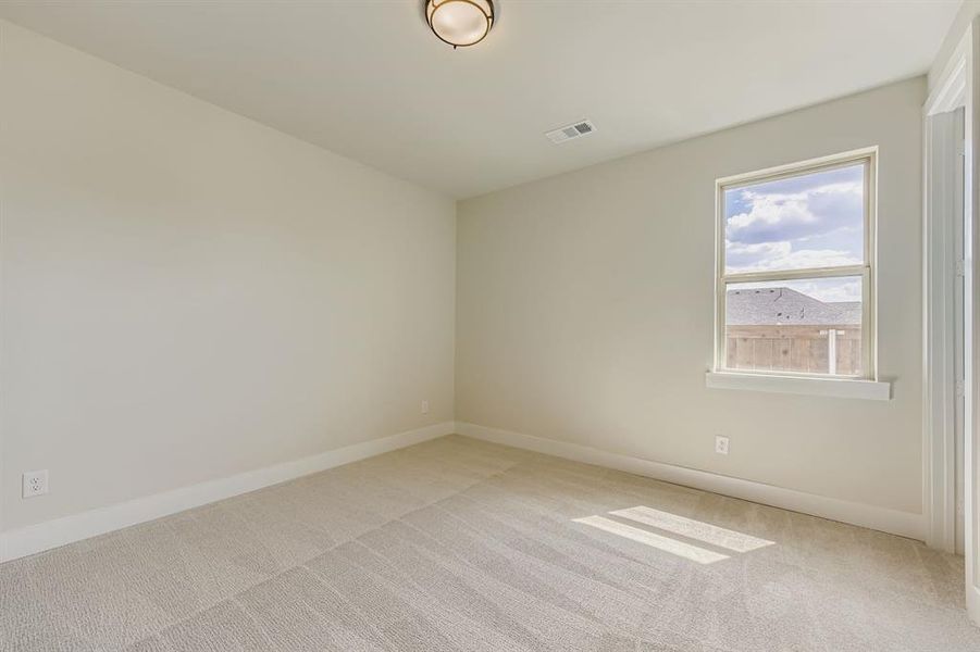 Spare room featuring baseboards and light carpet