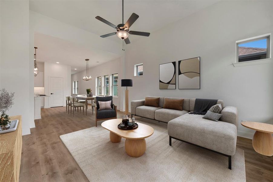 Spacious living area featuring a ceiling fan, wood-finish flooring, and high ceilings