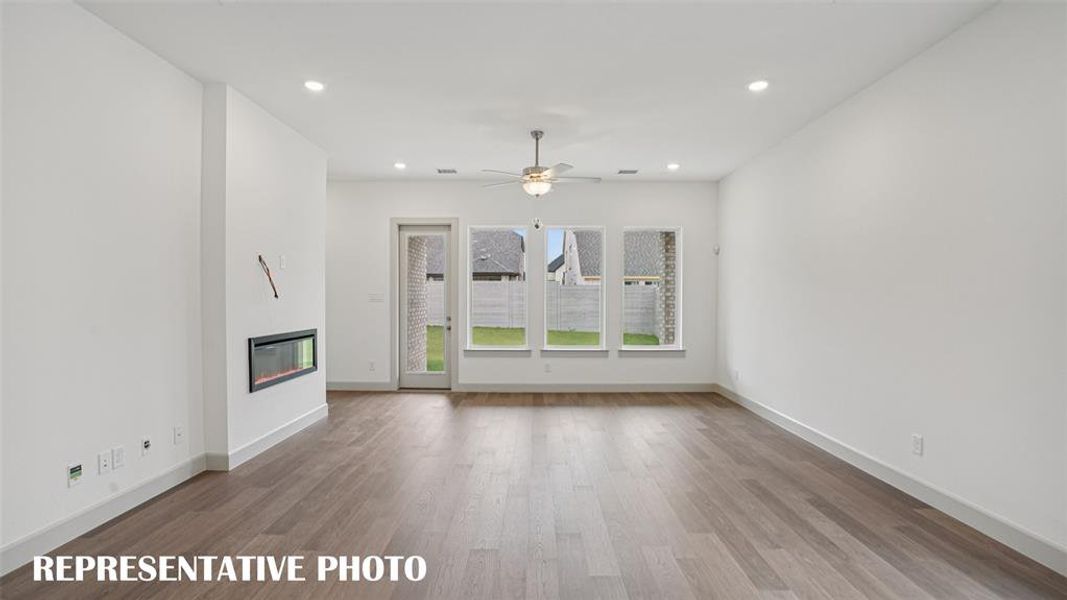 Featuring a wall of windows overlooking the back yard, this family room is where memories will be made!  REPRESENTATIVE PHOTO