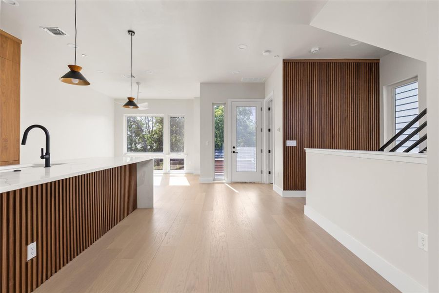 Clean lines and warm wood accents define this bright, open entrance foyer with hardwood flooring.