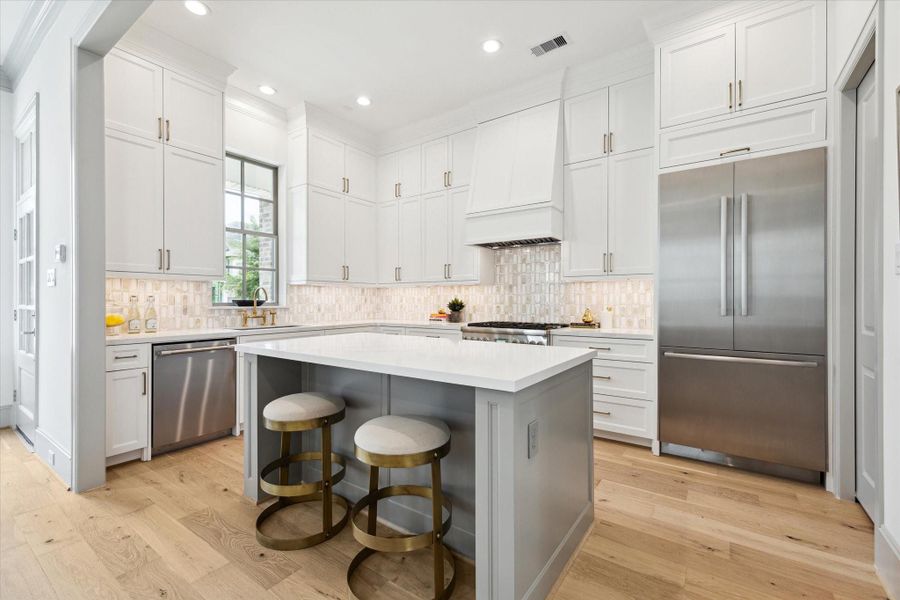 Kitchen features Thermador stainless steel appliances, Calacatta Gold Quartz countertops and Marble mosaic backsplash.