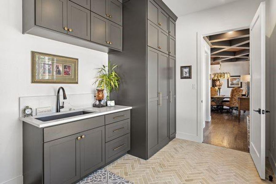 Utility Room area featuring gorgeous cabinetry, a deep sink and hided washer dryer.