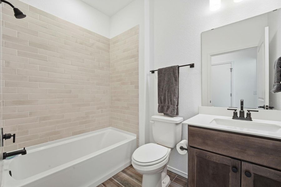 Bathroom featuring vanity, wood tiled floors, and bathtub / shower combination