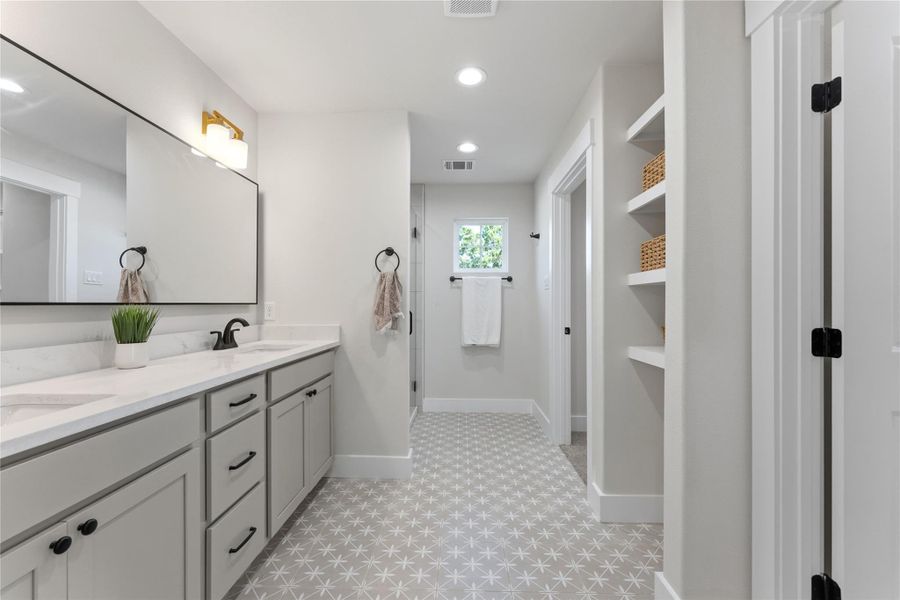 Organic, modern tile flooring pairs beautifully with oat-colored cabinetry and marble-look stone countertops. Generous storage and an oversized walk-in closet add everyday functionality.