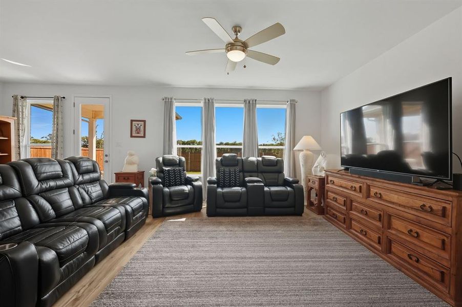 Living area featuring light wood-style flooring and ceiling fan Living area featuring light wood-style flooring and ceiling fan