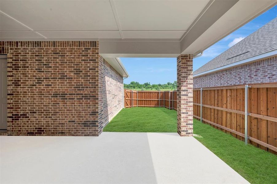 Covered patio featuring a concrete surface, a brick column, and a painted ceiling Covered patio featuring a concrete surface, a brick column, and a painted ceiling