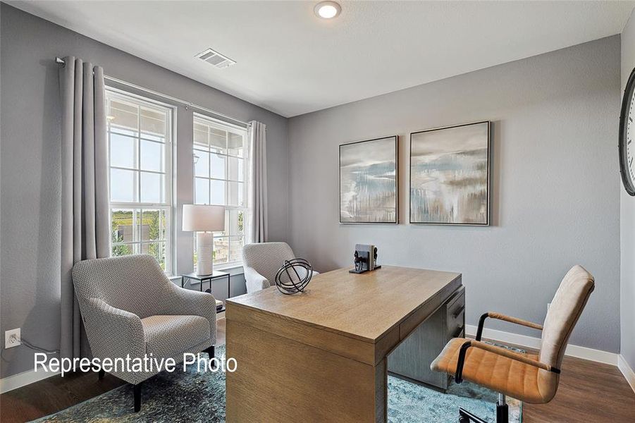 Dedicated interior room featuring light gray walls and wood-finish flooring