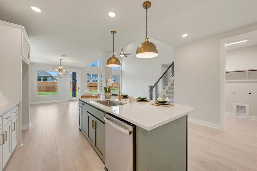 Kitchen island with integrated sink, white countertop, and sage green cabinetry