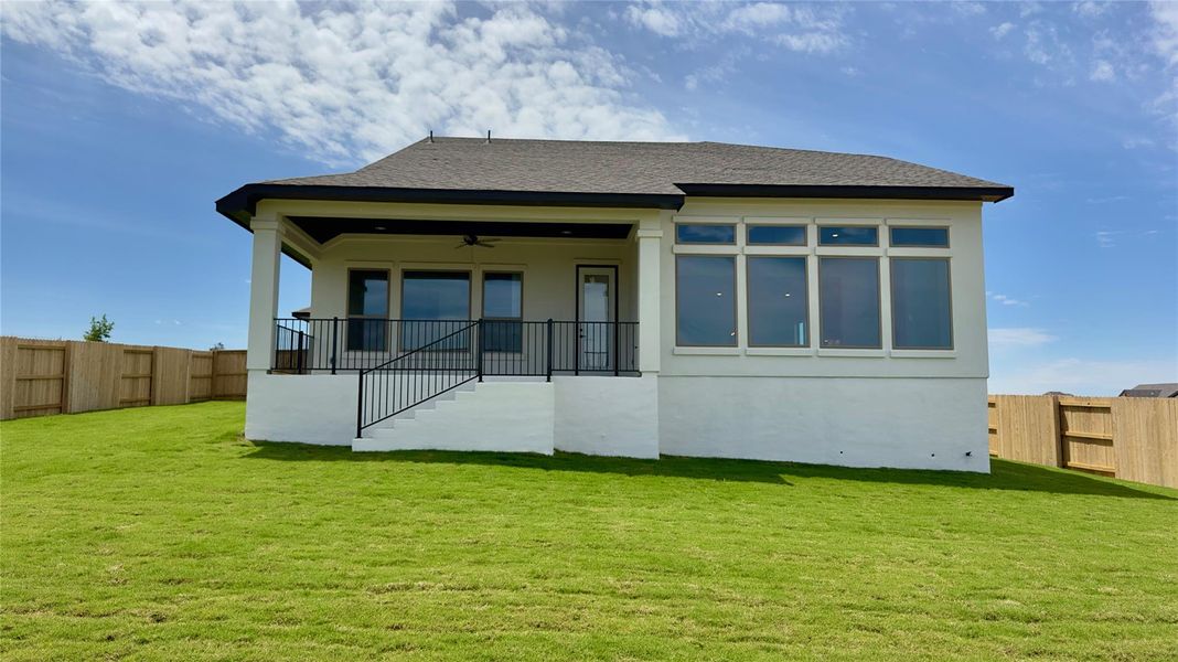 Back of property with ceiling fan, a patio area, roof with shingles, and stucco siding