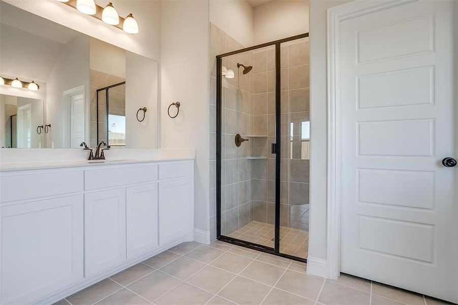 Bathroom with tile patterned flooring, vanity, and walk in shower