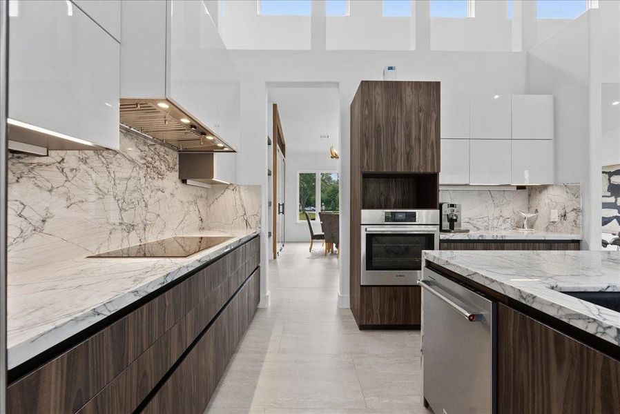 This space combines high-performance utility with the home's signature modern aesthetic. All cabinets are black teak finish with wood grain touch. Thermador INDUCTION cooktop.