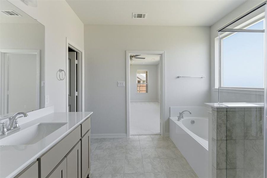 Full bath with vanity and a garden tub